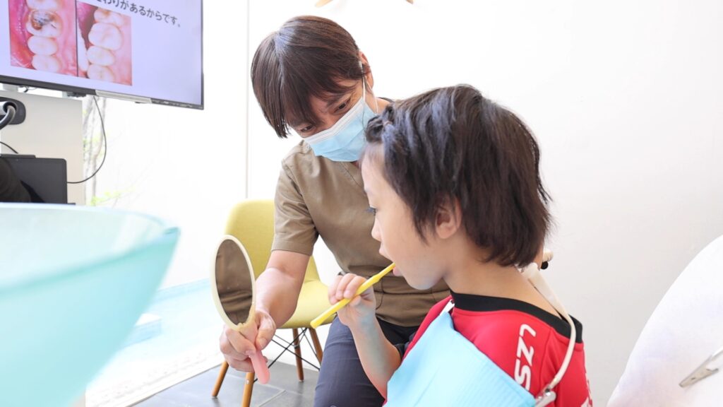 あゆみ歯科クリニックの福原医師が子どもに歯磨き指導をしているところ２