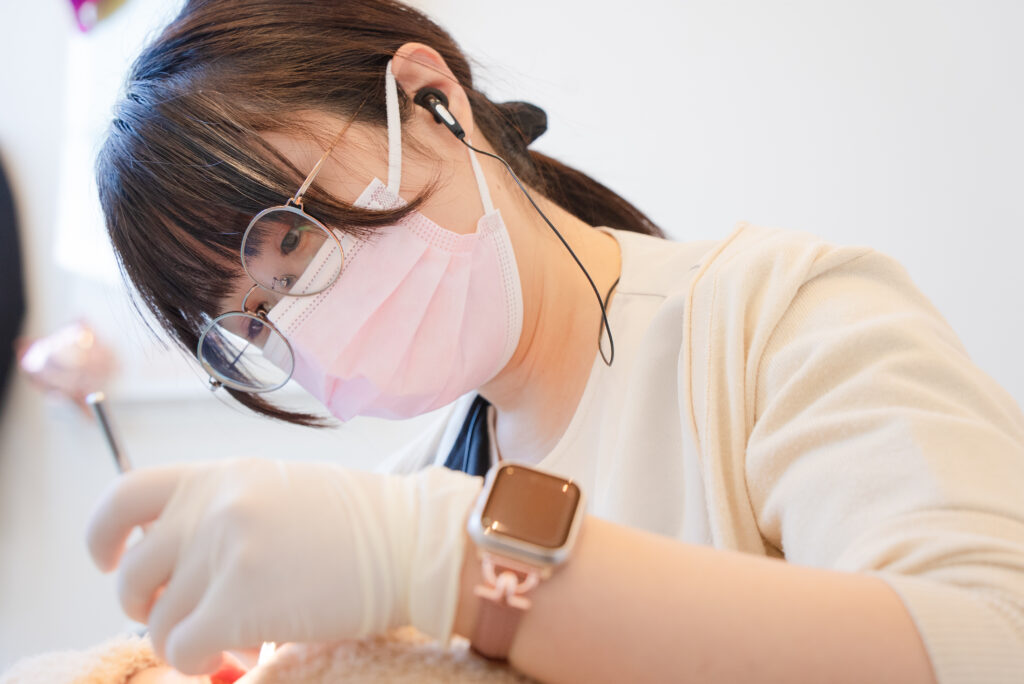 女性歯科衛生士が患者の歯科検診をしているところ。